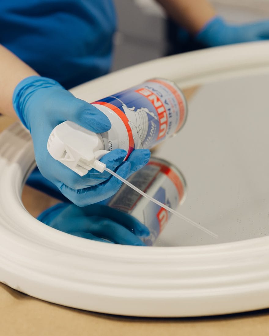 A gloved technician carefully cleaning a restored item